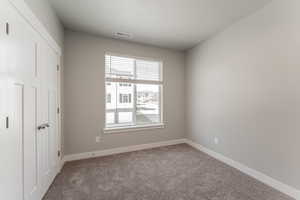 Carpeted spare room featuring a textured ceiling