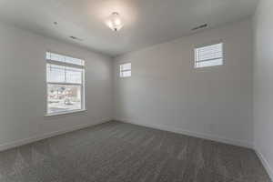 Carpeted empty room featuring a textured ceiling