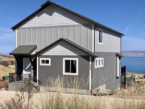 Back of property with a water and mountain view