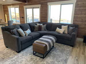 Living room with light hardwood / wood-style flooring and wooden walls