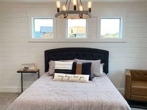 Carpeted bedroom featuring a chandelier