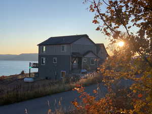 Back house at dusk featuring a water view