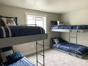 Bedroom with light colored carpet and a textured ceiling