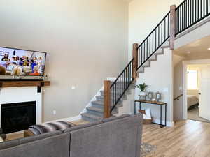 Living room with light hardwood / wood-style floors and a high ceiling