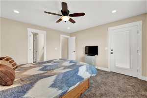 Primary carpeted bedroom featuring ceiling fan