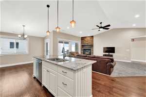 Kitchen with white island, sink, dishwasher, and pendant lighting