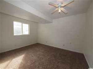 Lower level bedroom with ceiling fan and carpet flooring