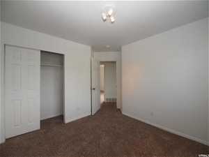 Upstairs bedroom featuring a closet and dark carpet