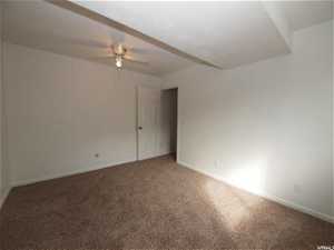 Lower level bedroom featuring ceiling fan and carpet