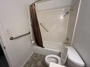 Bathroom with shower / tub combo with curtain and toilet