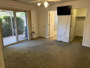 Master bedroom with ceiling fan, a walk in closet, a closet, carpet floors, and TV