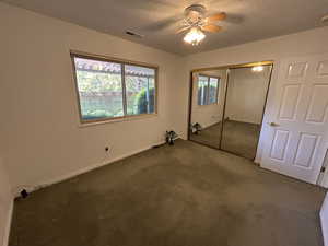 Unfurnished bedroom with window, ceiling fan, and closet