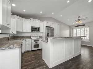 Kitchen featuring dark hardwood / wood-style flooring, ceiling fan, white cabinetry, and stainless steel appliances