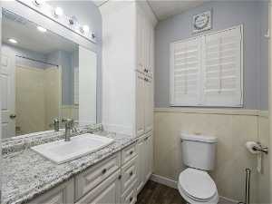 Bathroom featuring hardwood / wood-style floors, oversized vanity, and toilet