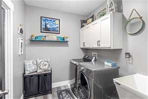 Laundry room featuring cabinets, and a wash basin