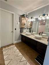 Bathroom with a textured ceiling, dual bowl vanity, and tile flooring