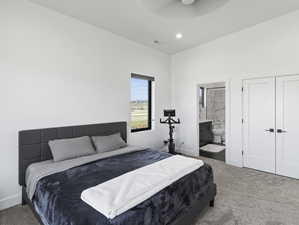 Bedroom with ensuite bath, ceiling fan, and carpet flooring