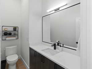 Bathroom with wood-type flooring, vanity, and toilet