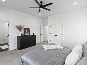 Carpeted bedroom with a closet and ceiling fan