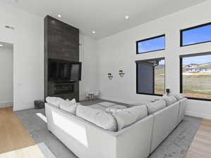 Living room with light wood-type flooring and a large fireplace