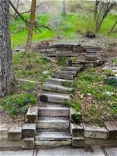 Staircase to firepit and walking/biking/running trail above back yard.