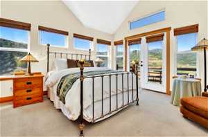 Primary Bedroom featuring high vaulted ceiling, french doors, carpet, and private deck