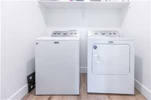 Laundry room with light hardwood / wood-style flooring and independent washer and dryer