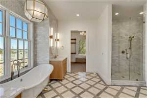 Bathroom featuring vanity with extensive cabinet space, shower with separate bathtub, and tile floors