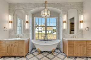 Bathroom featuring tile flooring, double sink vanity, tile walls, and a wealth of natural light