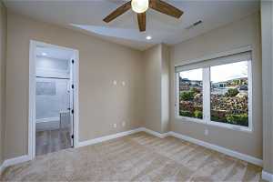 Empty room with light colored carpet and ceiling fan