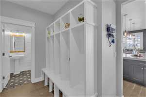 Mudroom featuring sink, light hardwood / wood-style flooring, and an inviting chandelier