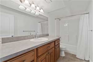 Full bathroom featuring shower / bathtub combination with curtain, toilet, tile flooring, a textured ceiling, and vanity