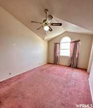 Master Bedroom with light carpet, lofted ceiling, and ceiling fan