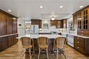 Kitchen with a kitchen island, plenty of natural light, premium white appliances, and light wood-type flooring