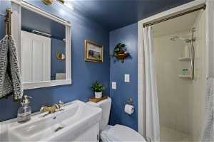 Bathroom with a shower with curtain, sink, and toilet