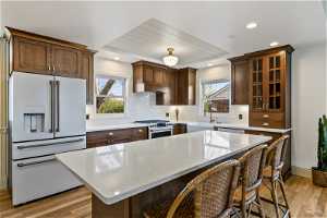 Kitchen with a center island, light wood-type flooring, premium appliances, and a wealth of natural light