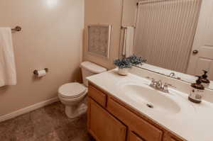 Bathroom with vanity, tile floors, and toilet