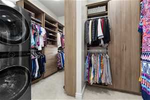 Owner's Suite Spacious closet with light carpet and optional stackable washer and dryer. Custom designed by Closet Butler