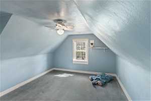 Bedroom with a ceiling fan, a textured ceiling, and a lofted ceiling