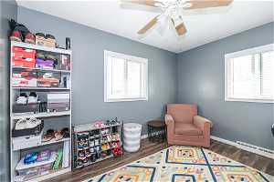 Game room with dark hardwood / wood-style floors, ceiling fan, and baseboard heating