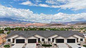 Ranch-style house featuring a mountain view, driveway, stucco siding, and a garage