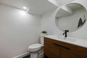 Bathroom featuring toilet, vanity, and tile flooring