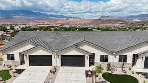 Ranch-style home featuring a mountain view, stucco siding, and stone siding