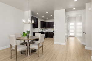 Dining area with light wood-style flooring, recessed lighting, a chandelier, and baseboards