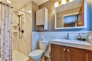 Bathroom with a shower with curtain, vanity, and toilet