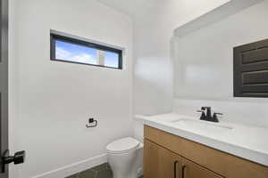 Bathroom featuring toilet, vanity, and tile patterned floors