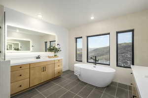 Bathroom featuring tile patterned flooring, a washtub, a mountain view, and vanity