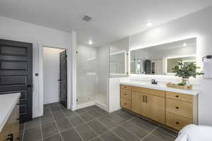 Bathroom with a shower, vanity, and tile patterned flooring