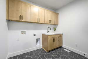 Laundry area featuring electric dryer hookup, cabinets, dark tile patterned floors, and hookup for a washing machine