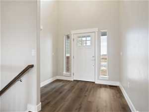 Entryway with a wealth of natural light, dark hardwood / wood-style flooring, and a high ceiling